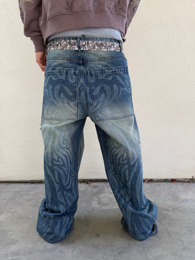 Back view of the Tribal Outlaw Denim showing faded tribal print down both legs, outdoors