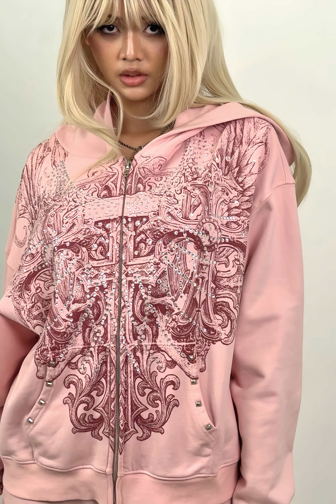 Model with blonde hair wearing the pink Bonnie Hoodie zipped, close front view of the print
