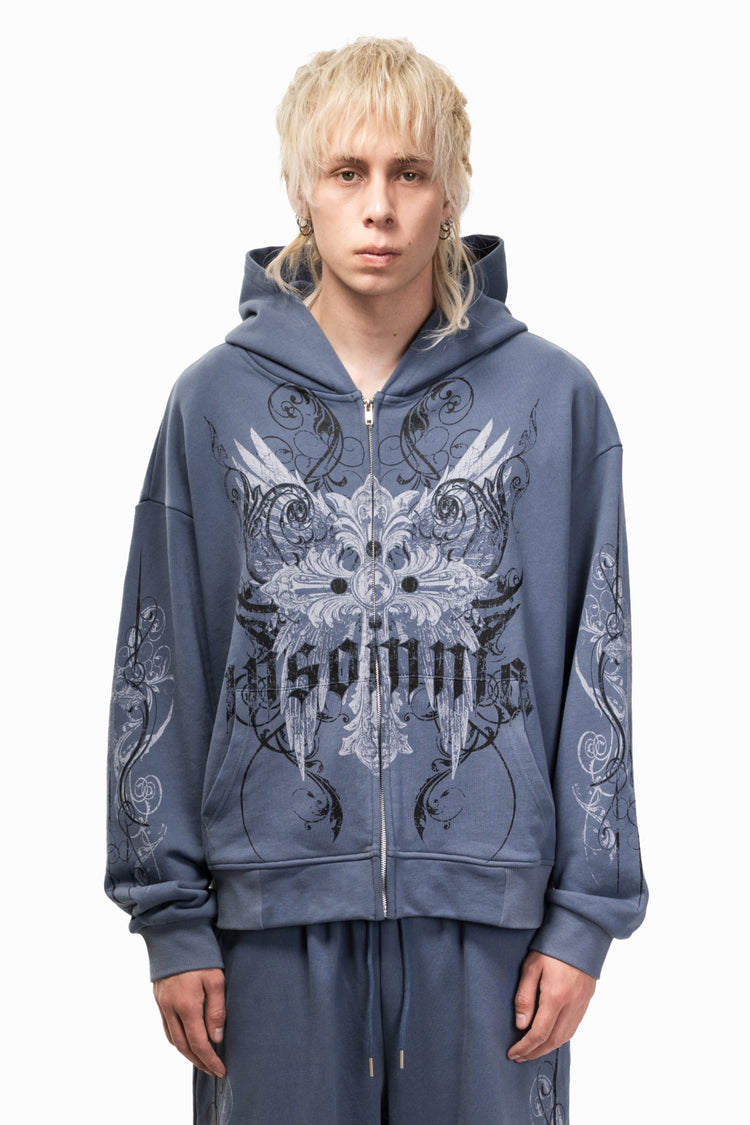 Model wearing the Midnight Blue Crux Hoodie zipped up, showing the silver gothic Insomnia print