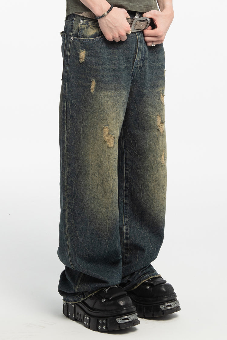 Side close view of the Sand Outlaw Denim showing faded whiskering and stacked hems