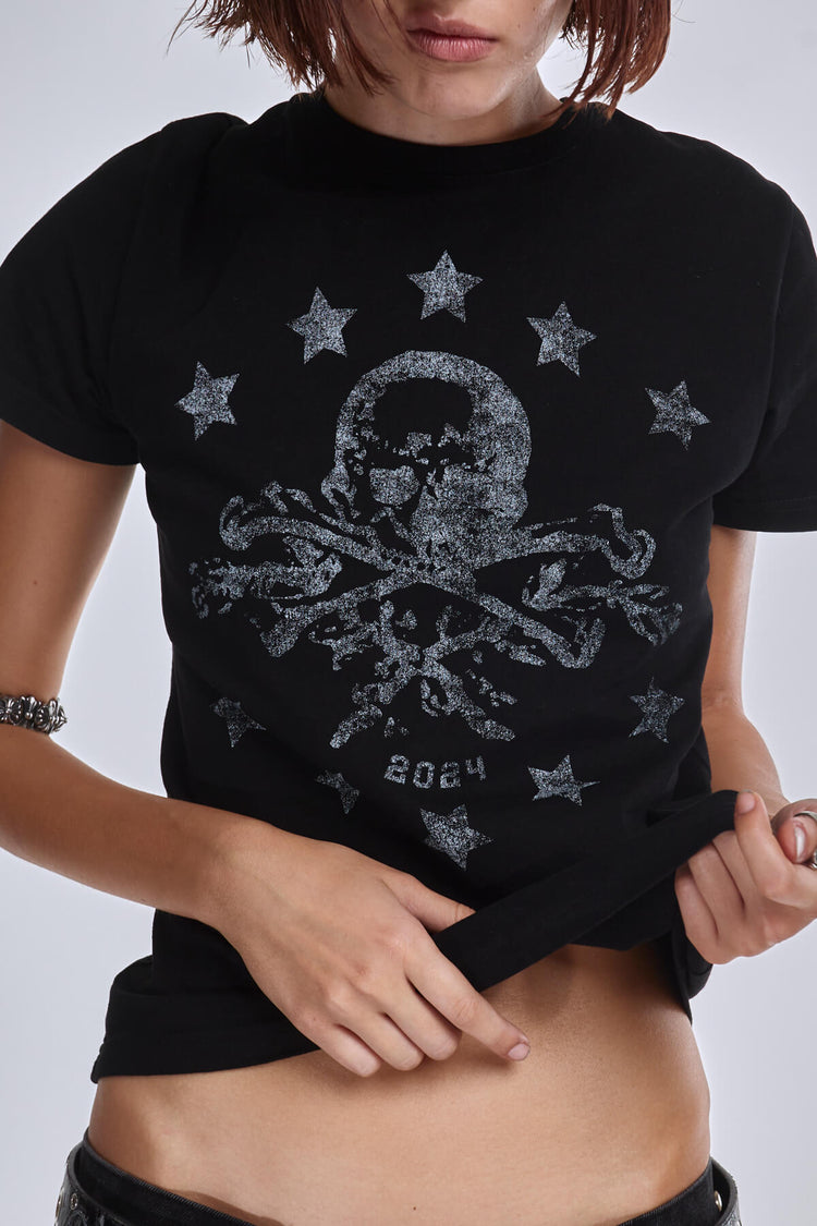 Close-up of the black Prestige Tee skull and stars print, worn cropped and lifted
