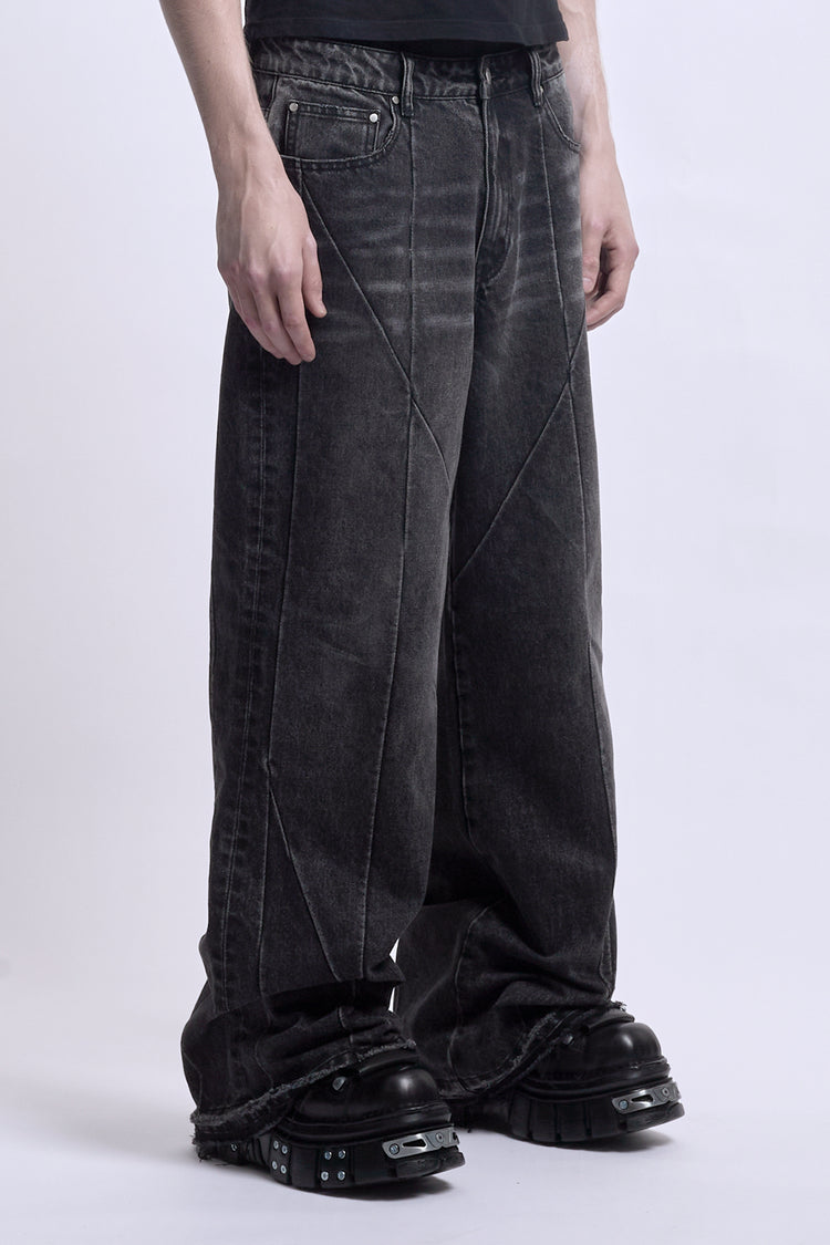 Side view from the waist down of the black Vex Denim with curved seam panels and frayed hems