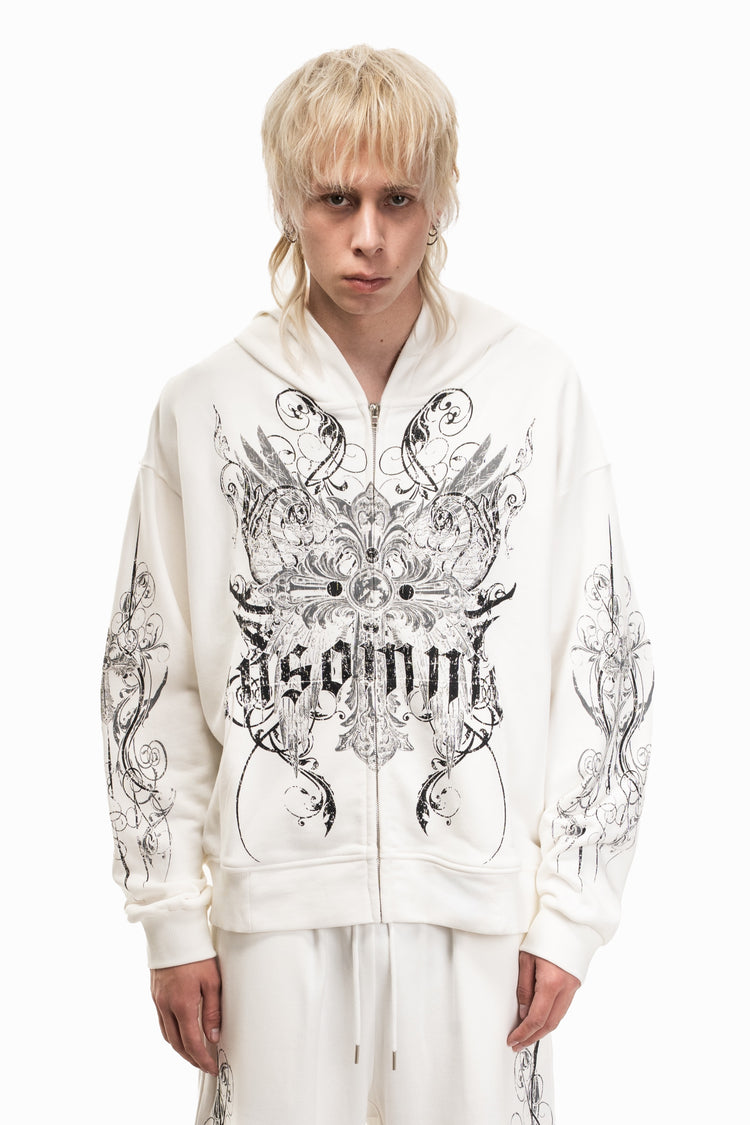 Blonde model in the zip-up White Crux Hoodie with black ornate graphic