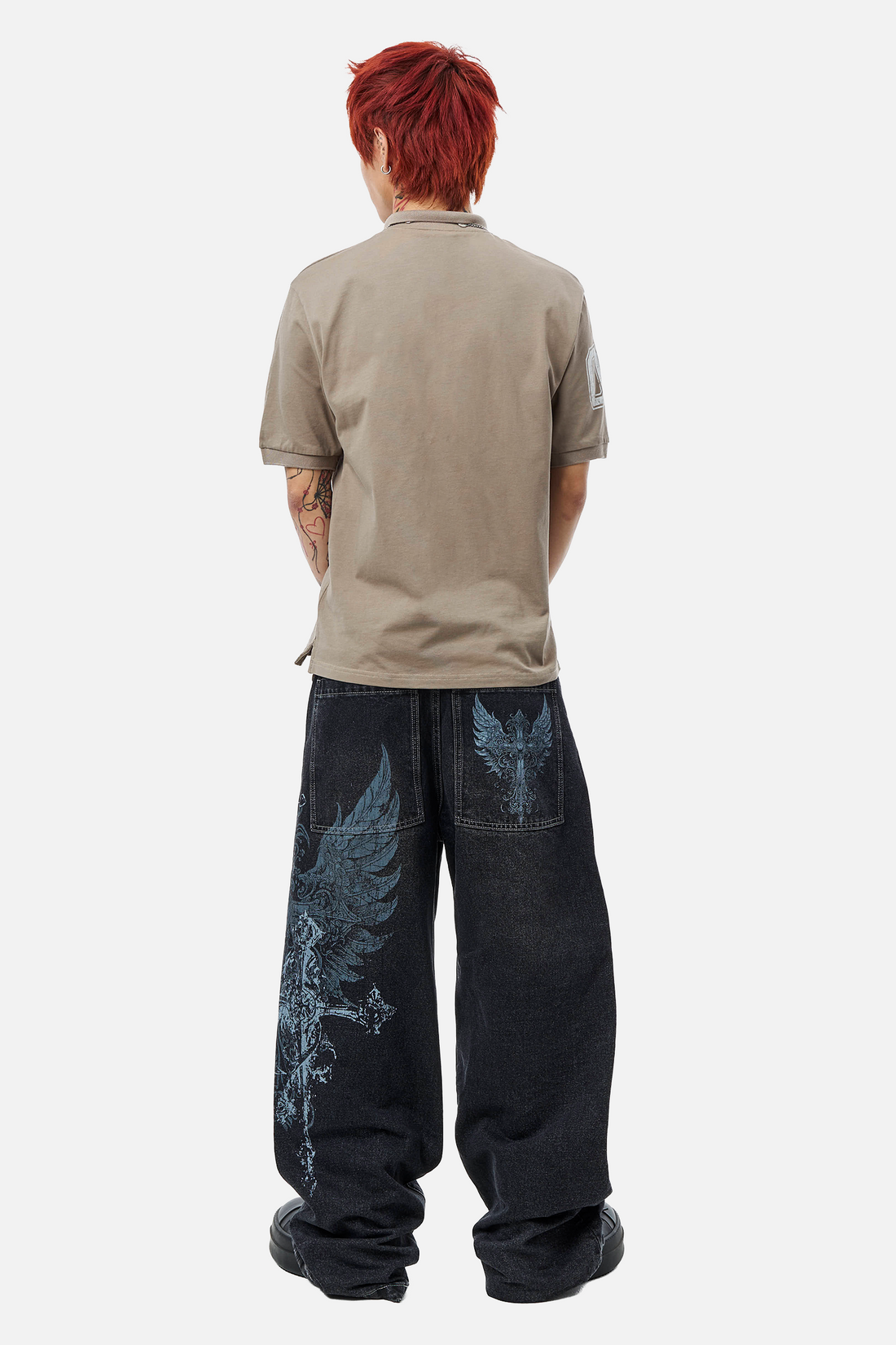 Back view of the plain taupe Reaper Polo with dark wing-print wide-leg jeans