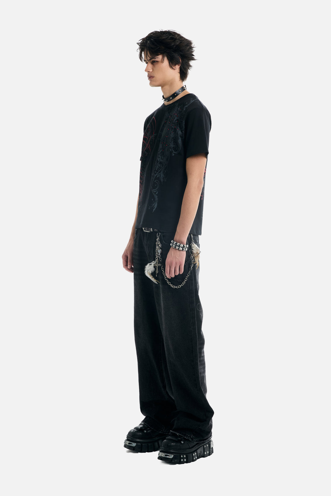 Side profile of the Black Scripture Eclipse Tee worn with black jeans and boots