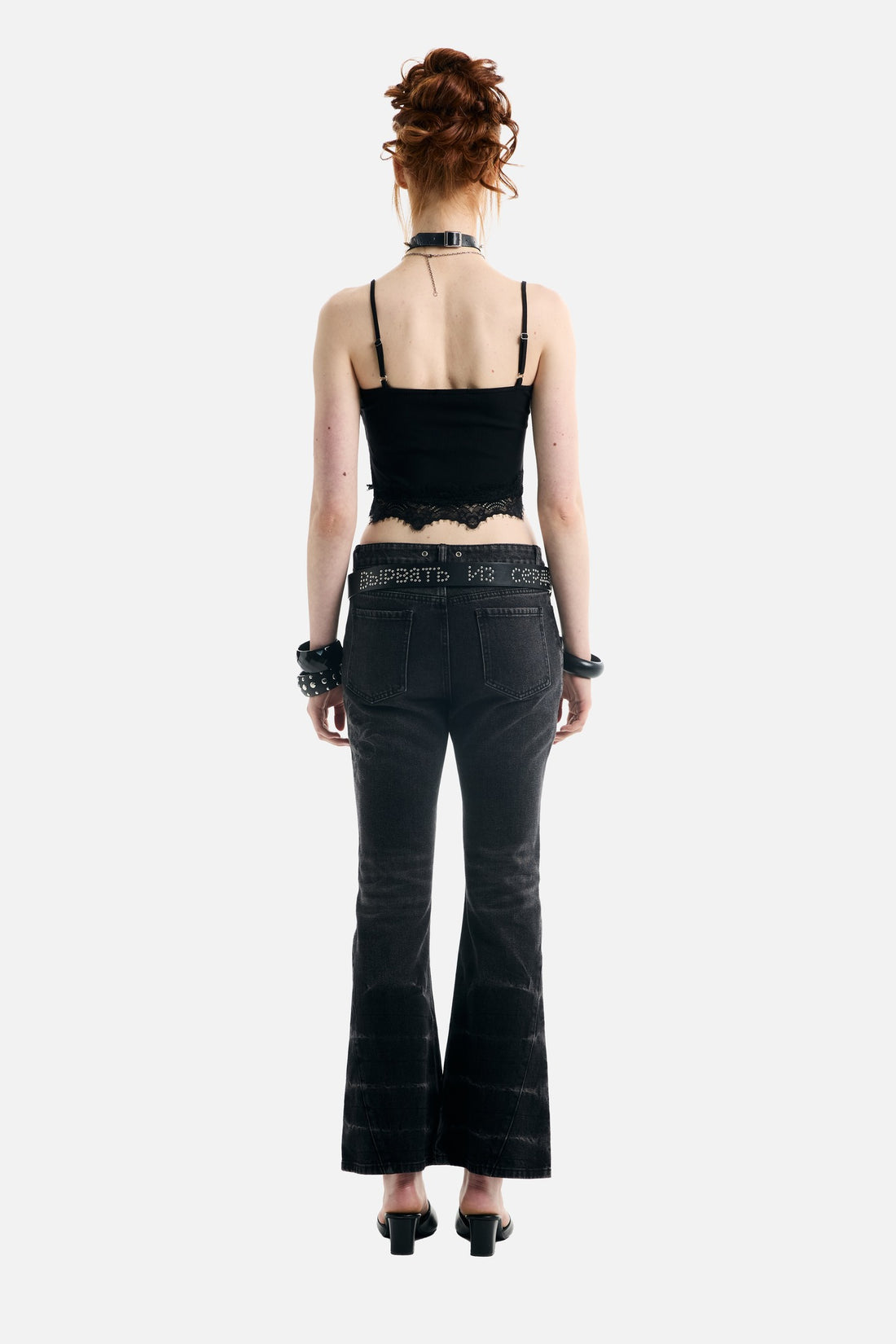 Back view of the Blessed Rhinestone Lace Crop Tank with thin straps and flared jeans