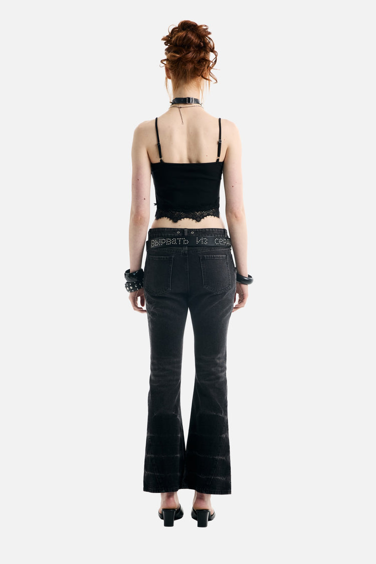 Back view of the Blessed Rhinestone Lace Crop Tank with thin straps and flared jeans