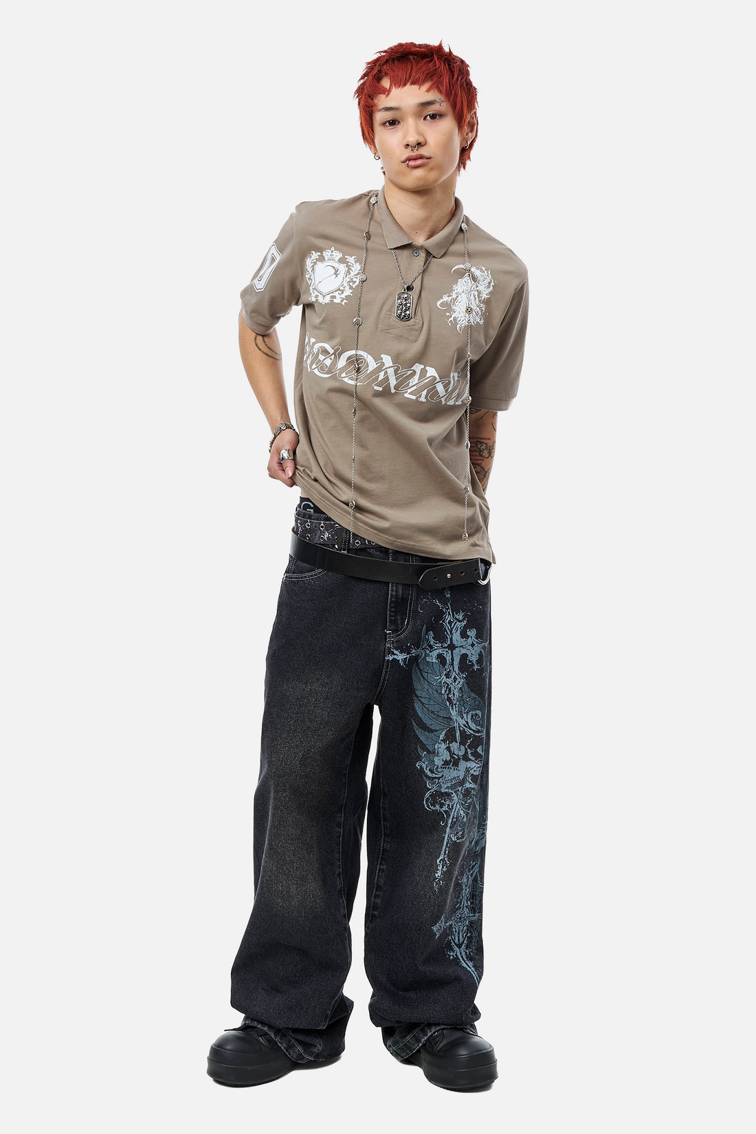 Full-length front view of the taupe Reaper Polo with dark wing-print baggy jeans
