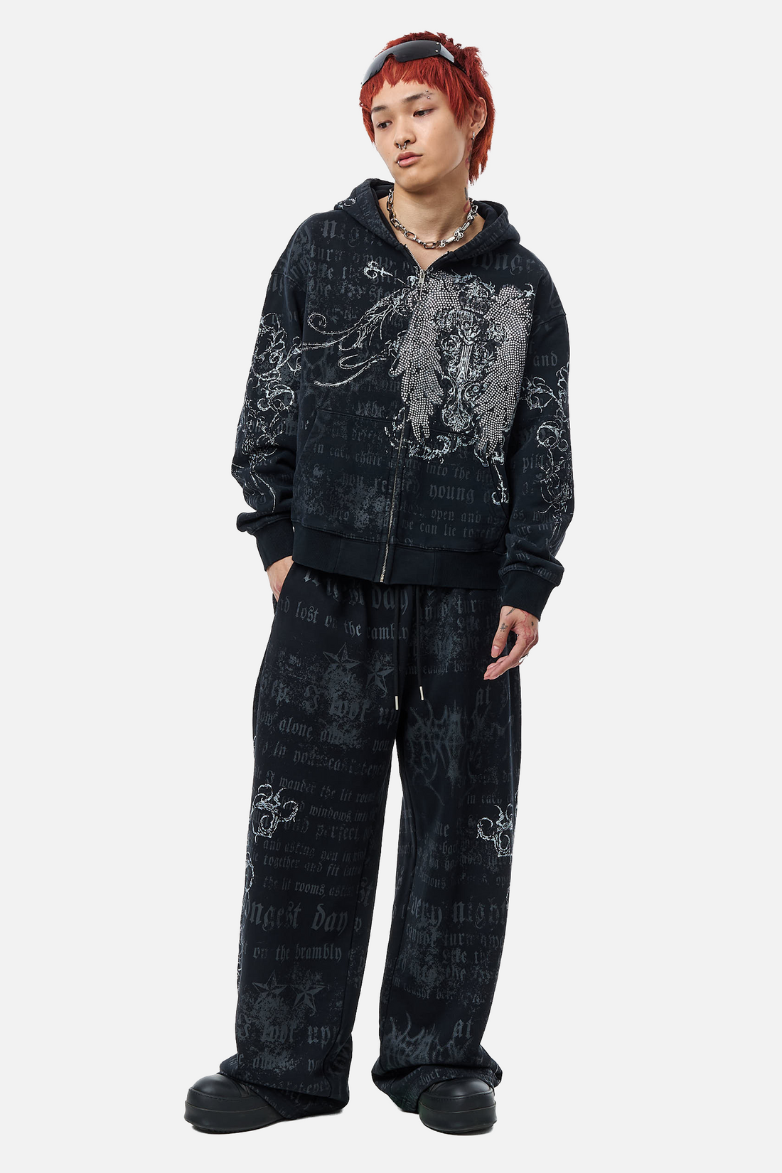 Model wearing the Sacred Zip Hoodie with matching printed sweatpants, full-length front view