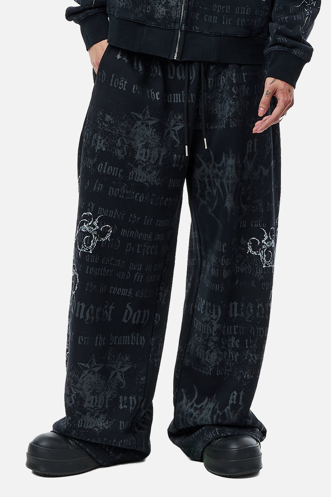 Three-quarter view of the Sacred Sweatpants with drawstring waist and all-over text print