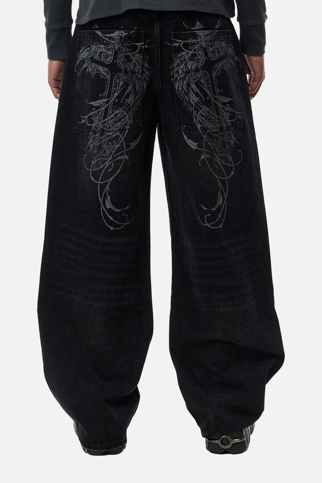 Back view of the black Harmony Jeans on model, with grey embroidered wings on the back pockets