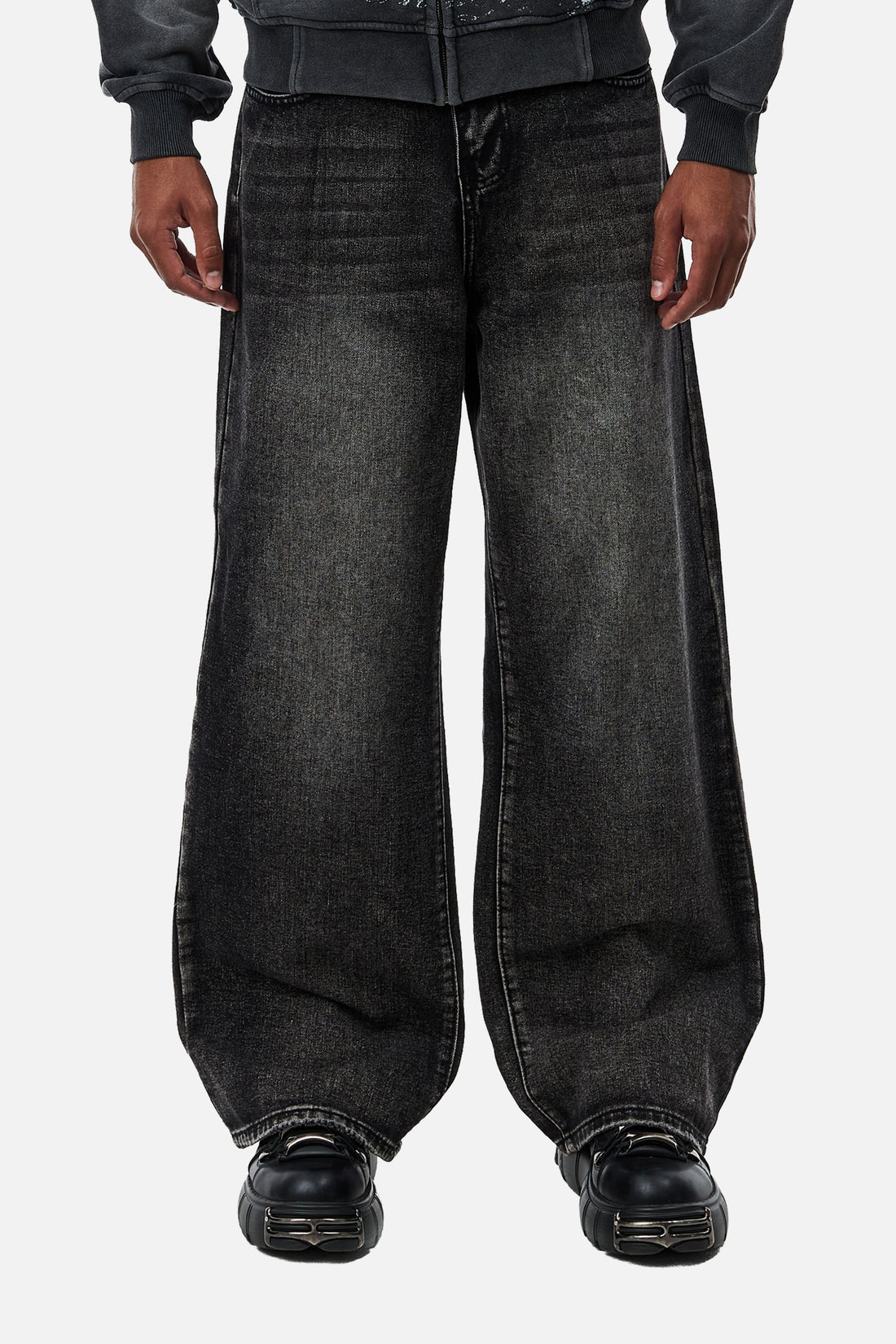 Front view of the Washed Black Outlaw Denim, a baggy faded fit with black chunky shoes