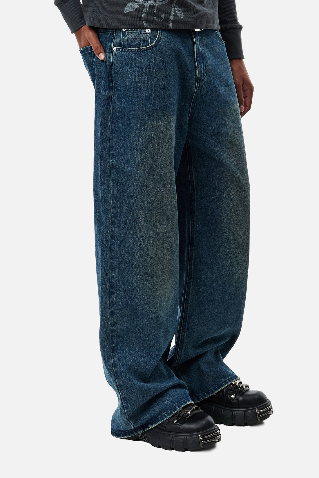Side close-up of the Washed Blue Outlaw Denim pooling over black chunky shoes
