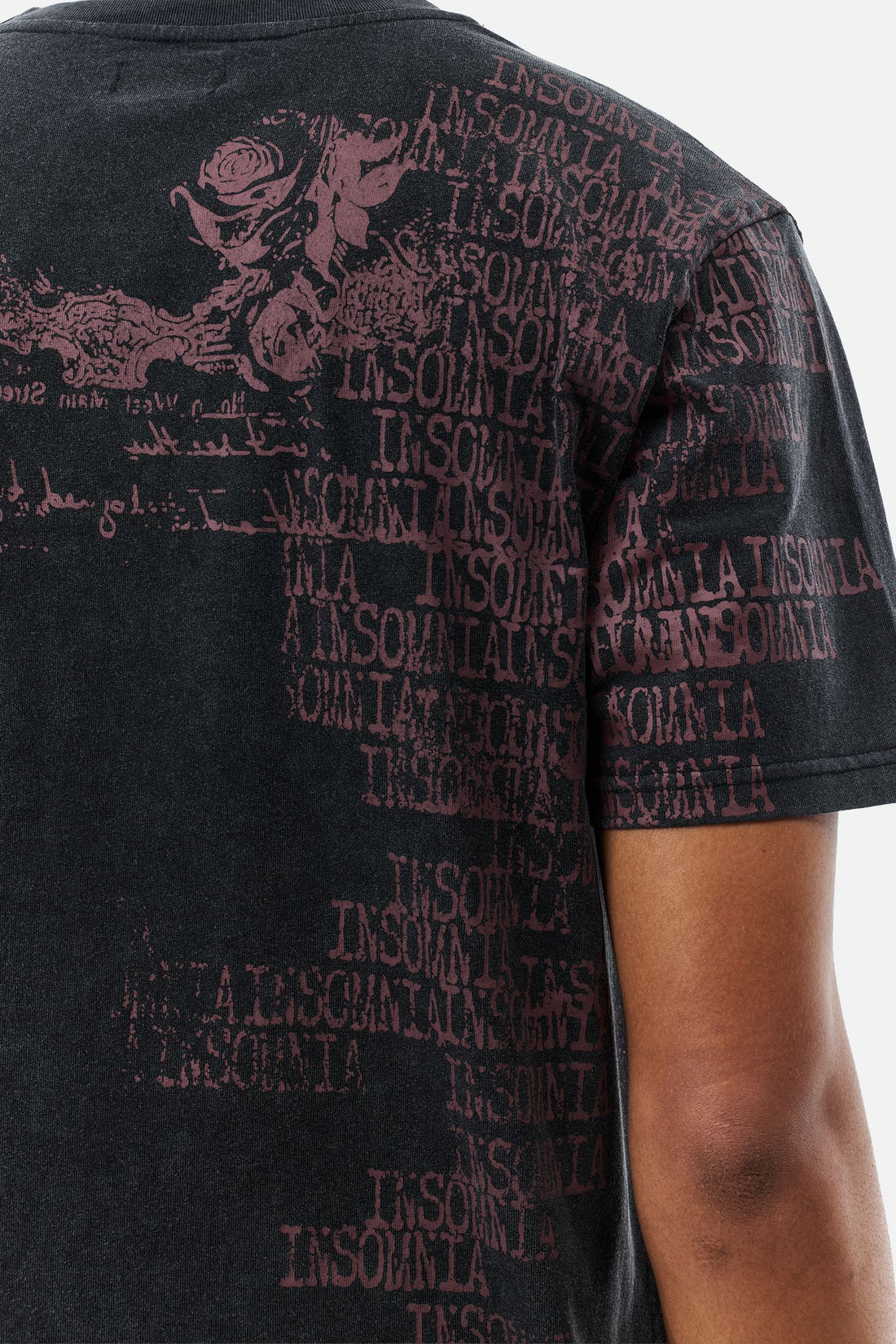 Close-up of the back of the Black Messages Tee showing repeated red Insomnia text print