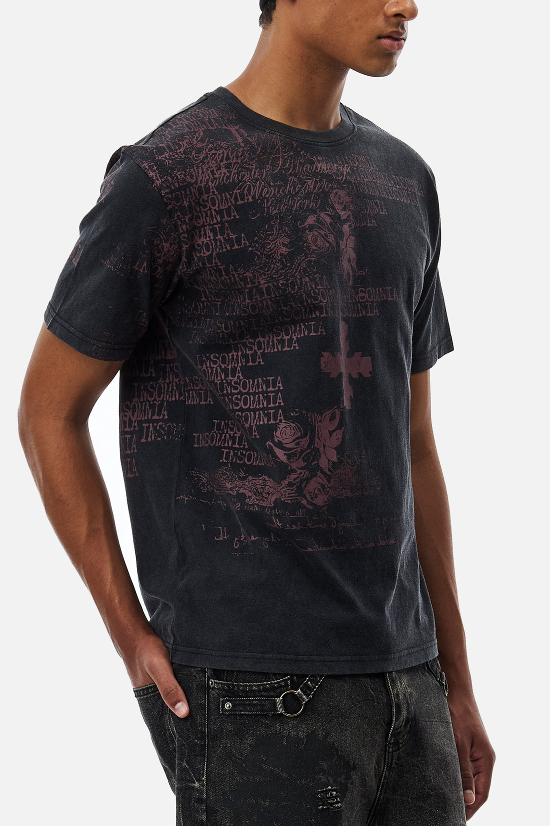 Side view of the Black Messages Tee worn with distressed grey jeans and a chain