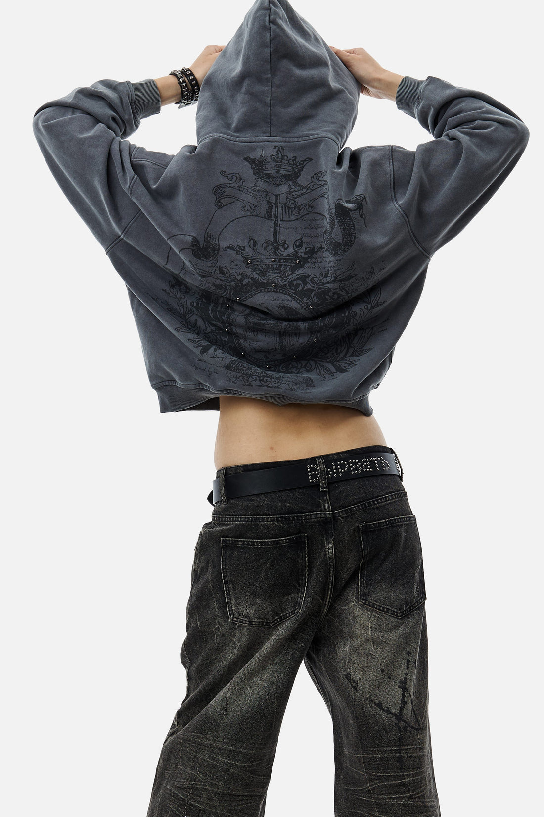 Back view of the Crest Hoodie pulled up with hood on, worn with faded black jeans