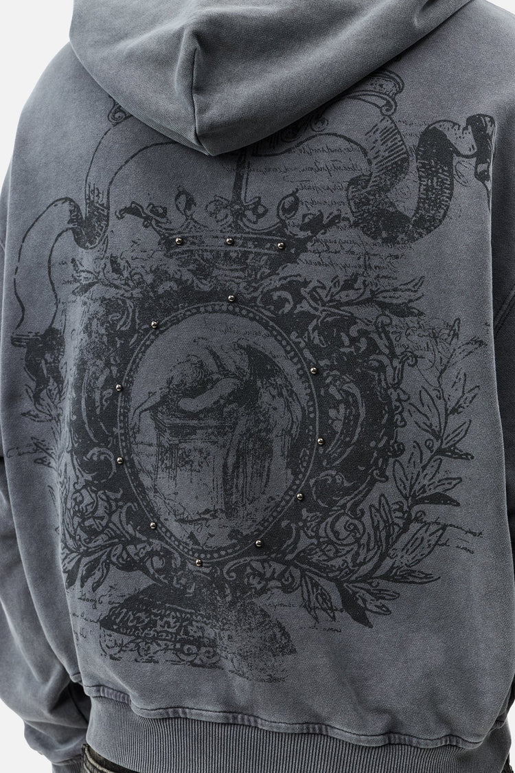 Close-up of the Crest Hoodie back print, studded ornate crest with crown