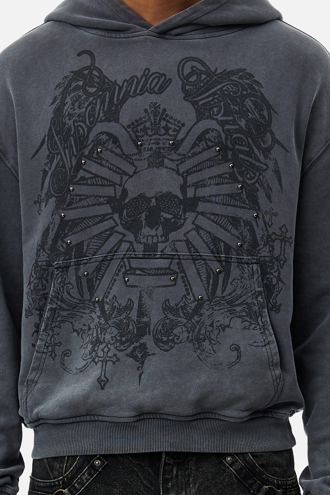 Close-up of the Crest Hoodie front showing studded skull and wings print