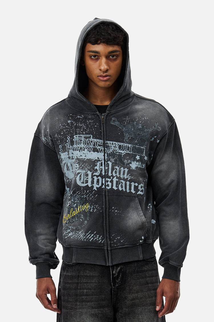 Model wearing the washed black Upstairs Zip Hoodie with hood up, front view of the graphic