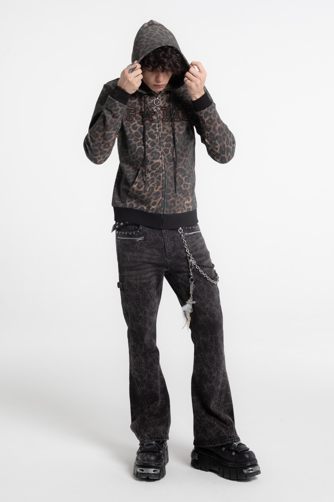 Model pulling up the hood of the FAME Slim Zip Hoodie, full-length front view