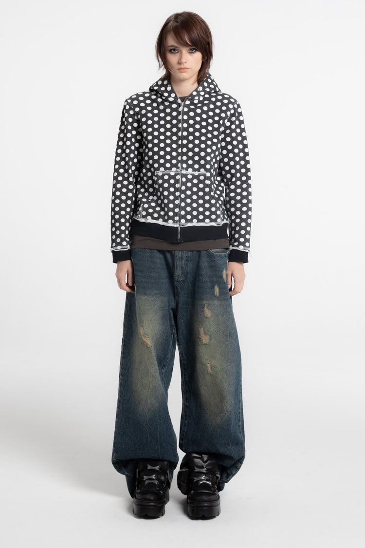 Model in the Black Polka Dot Slim Zip Hoodie with baggy faded jeans, full-length front view