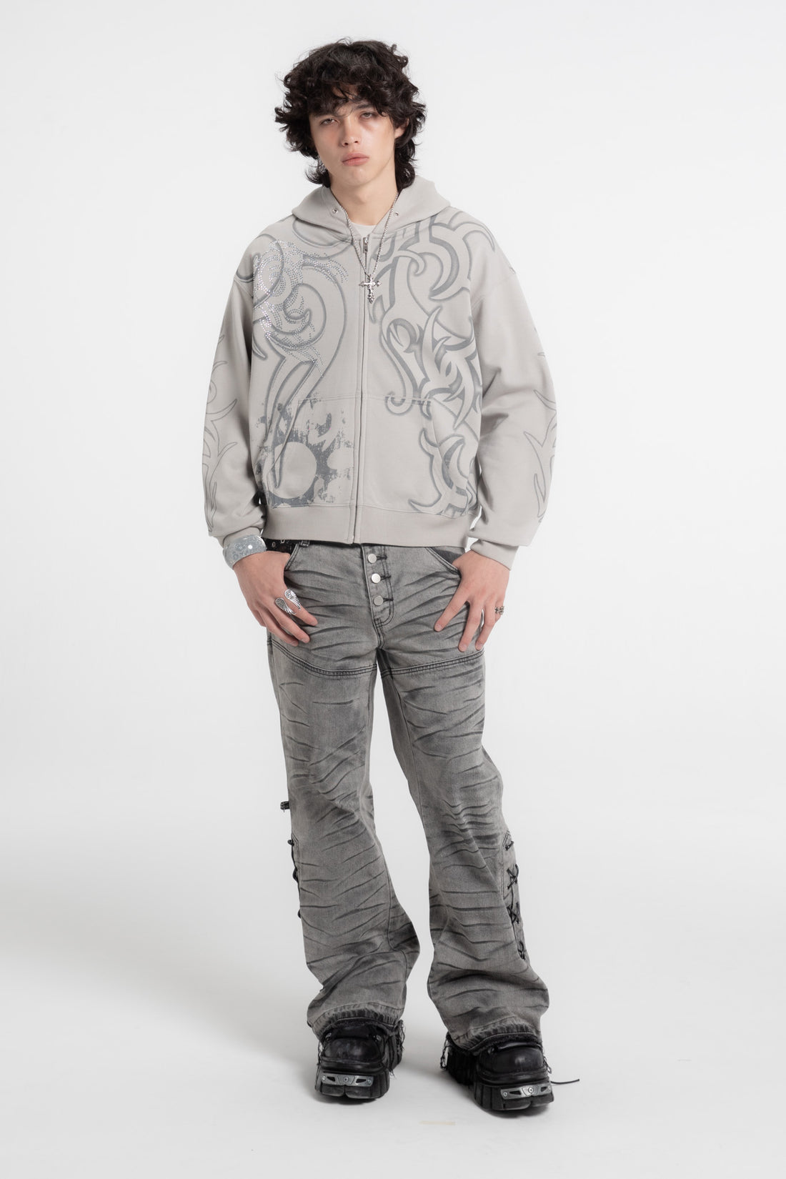 Model in the Rhinestone Tribal Zip Hoodie with gray flared jeans and black boots, full-length