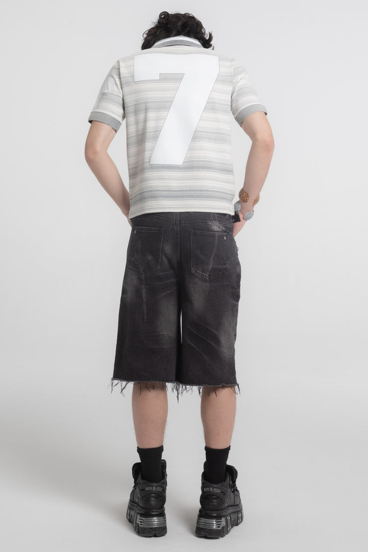 Full-length back view of the Striped Crest Polo with black denim shorts and boots