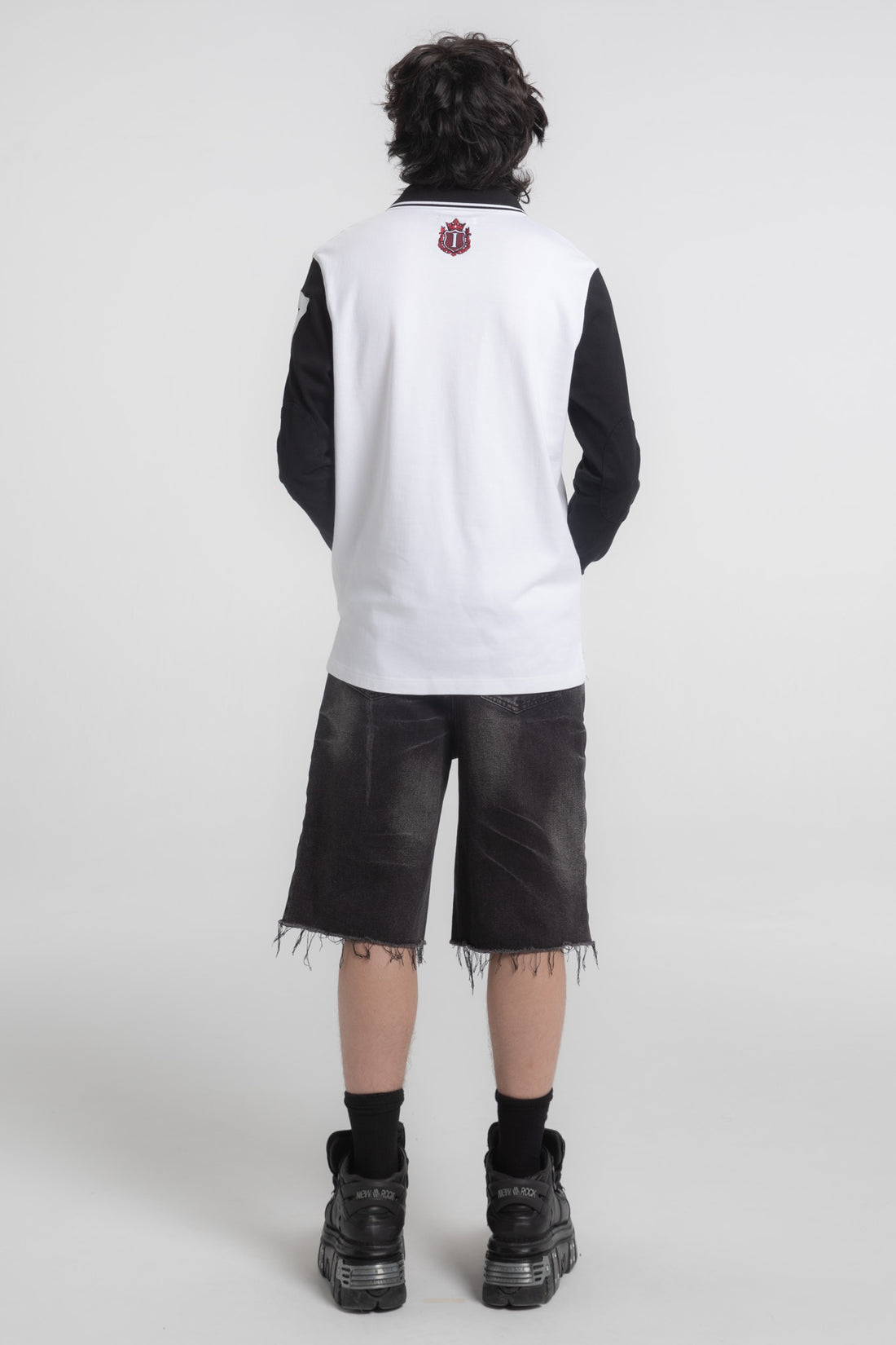 Full-length back view of the Crest Long Sleeve Polo with black cutoff shorts