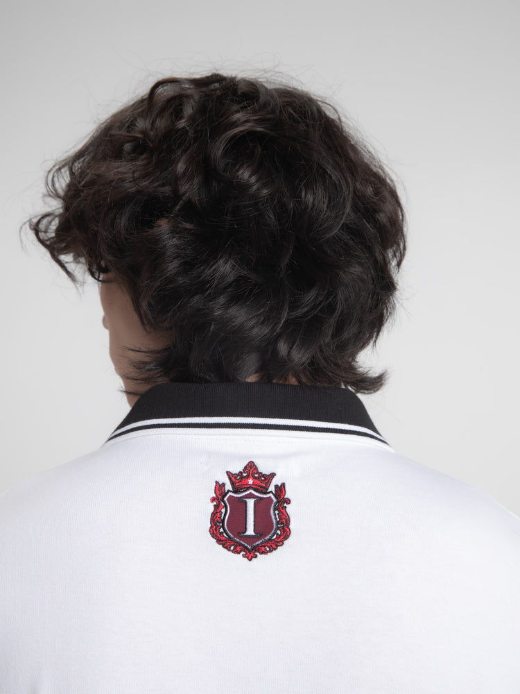 Close-up of the red embroidered crest on the back collar of the Crest Long Sleeve Polo