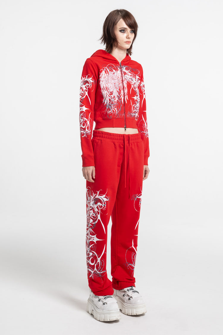 Full-length angled view of the Red Eclipse Cropped Hoodie zipped with red sweatpants