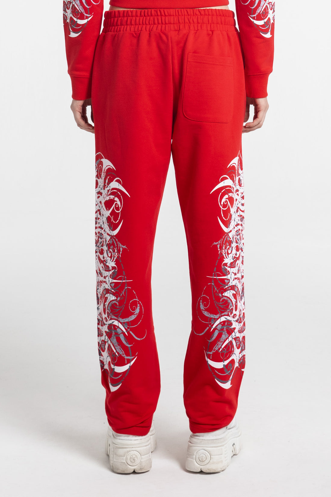 Back view of the Red Eclipse Sweatpants showing the white tribal print on both legs