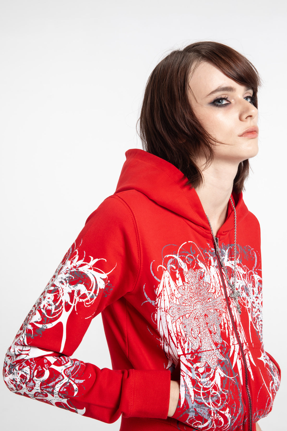 Three-quarter view of the Red Eclipse Cropped Hoodie showing the printed sleeves