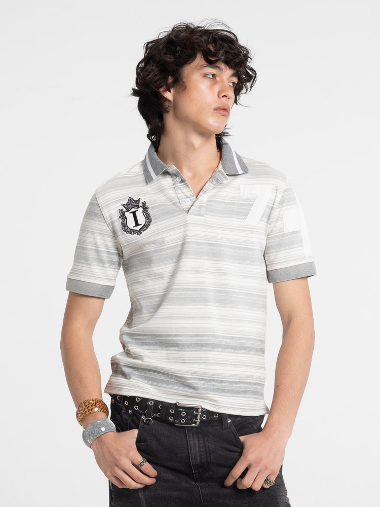Model wearing the grey and white Striped Crest Polo with black crest patch, front view