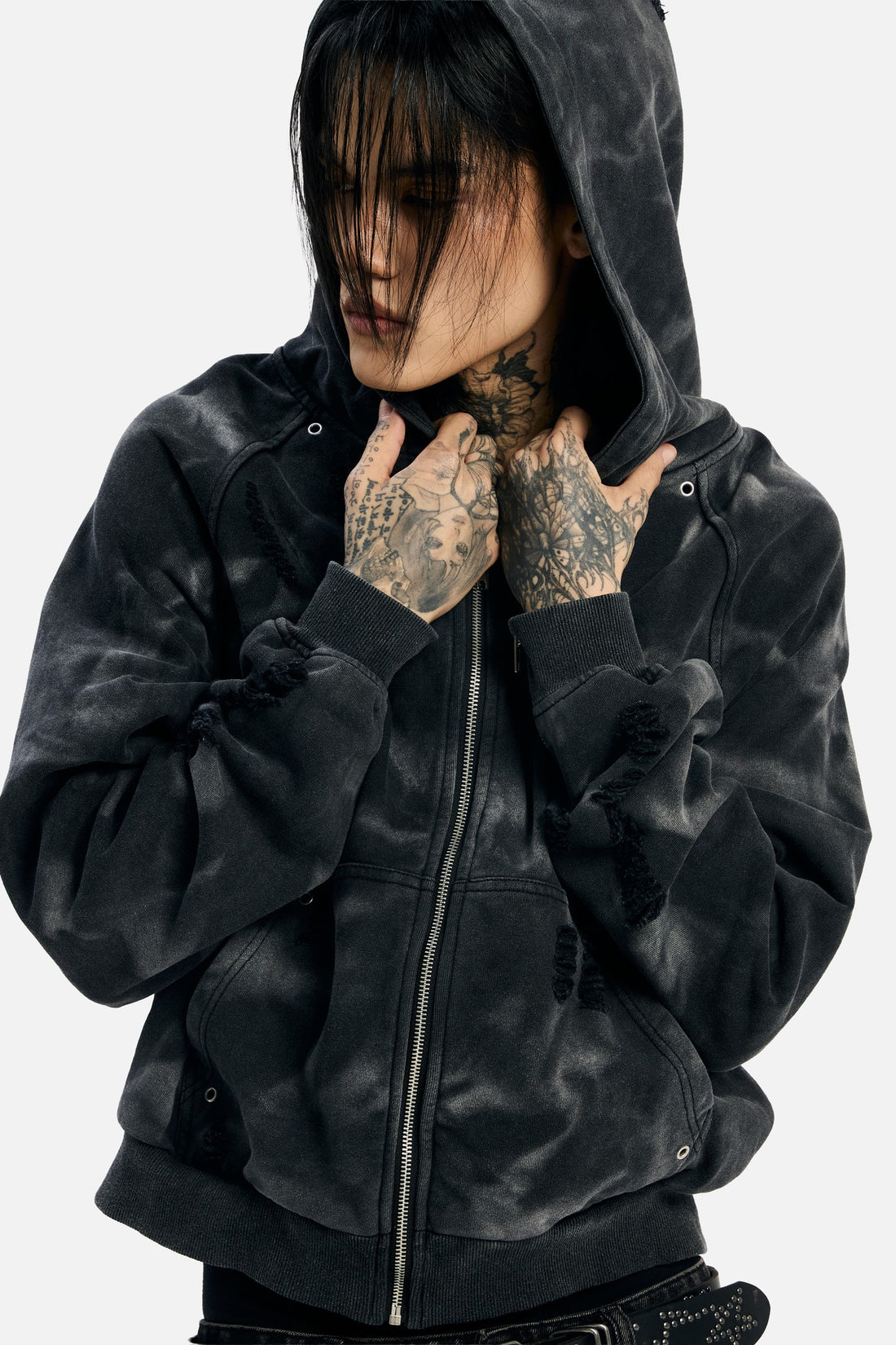 Close-up of a model pulling the hood of the Studded Raglan Zip Up Hoodie