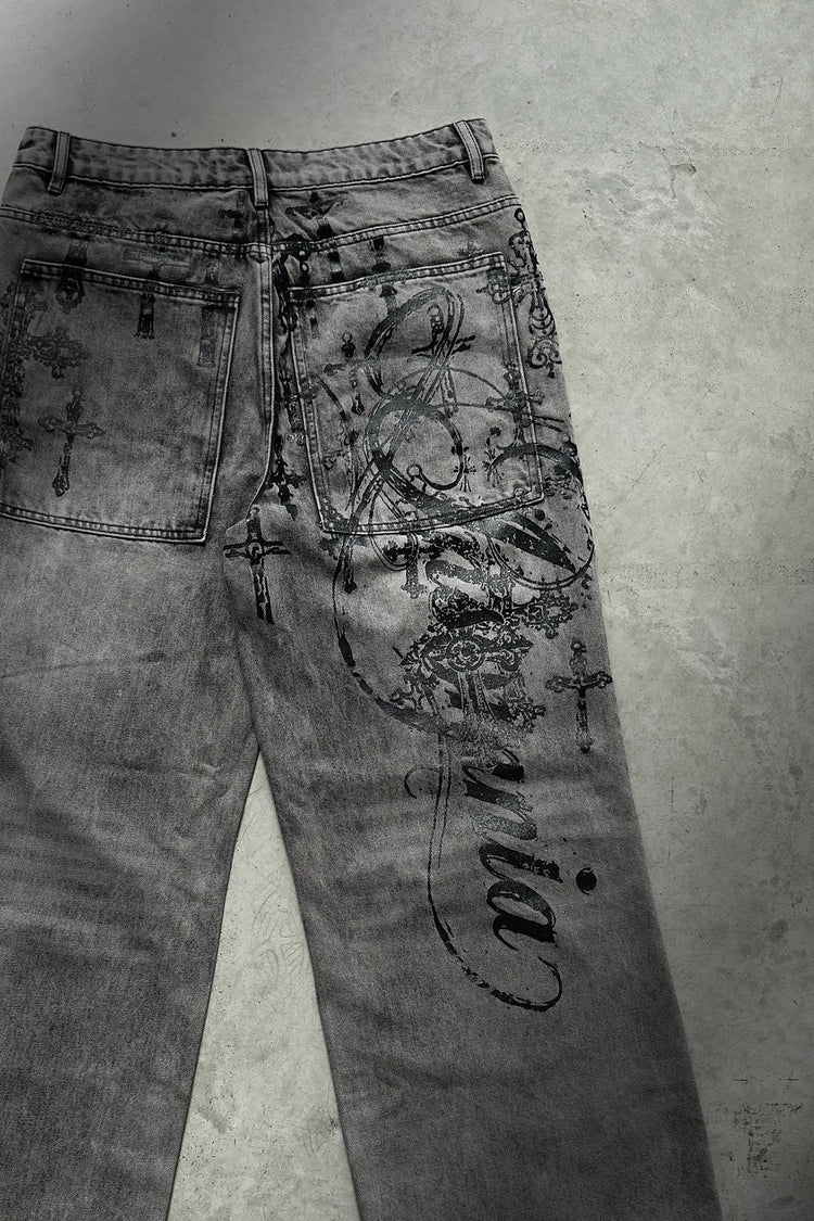 Back of the Cross Outlaw Denim laid flat on concrete, showing the Insomnia script down the leg