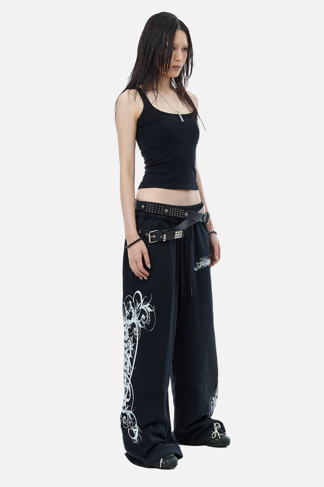Three-quarter view of the Eternal Sweatpants worn low with layered studded belts