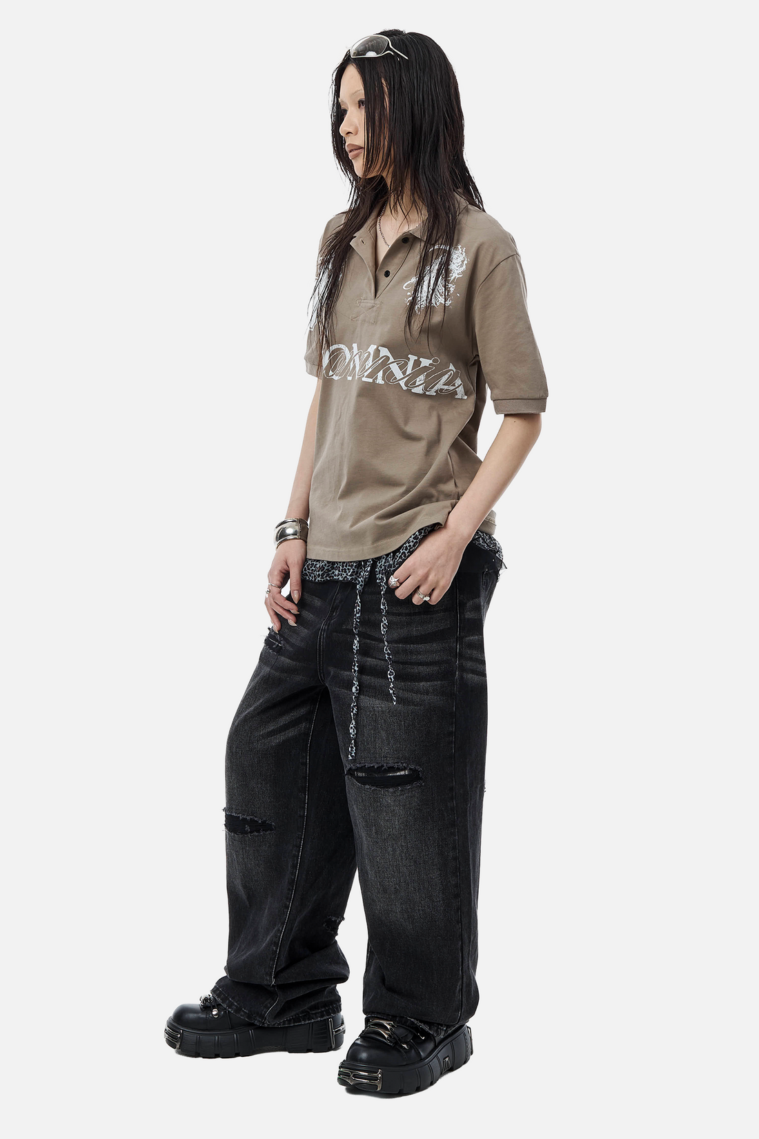 Full-length side view of the Reaper Polo styled with black ripped baggy jeans