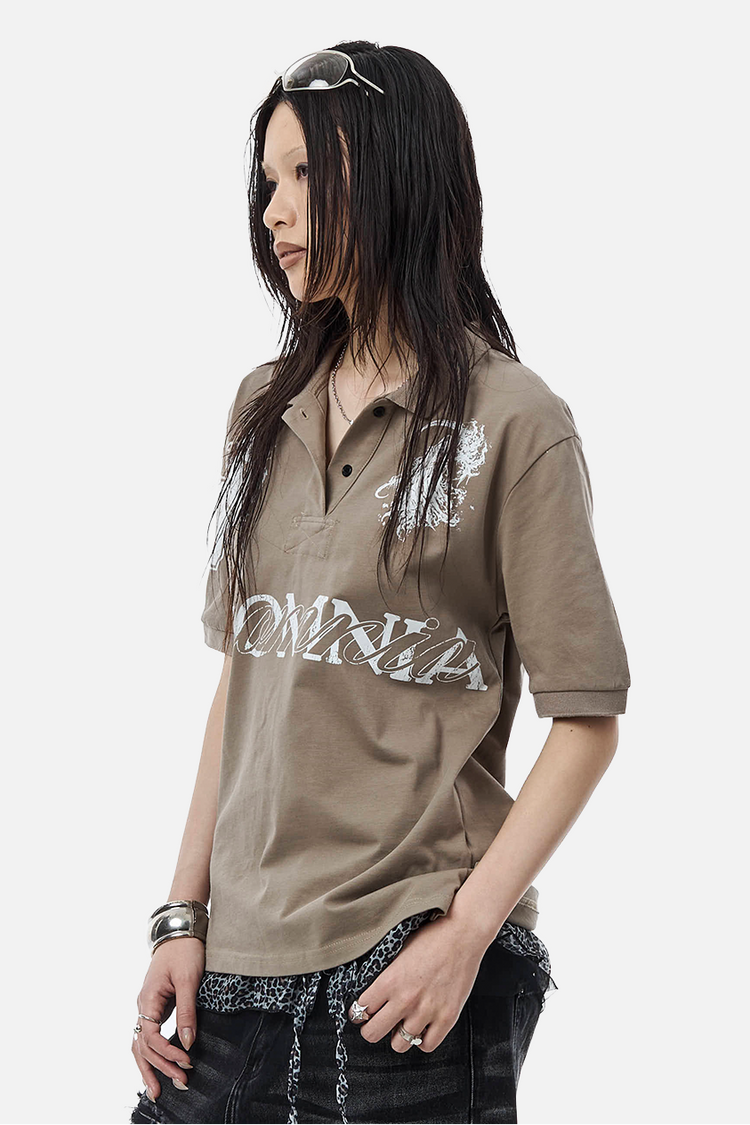 Side view of the taupe Reaper Polo on a long-haired model, showing silver Insomnia print