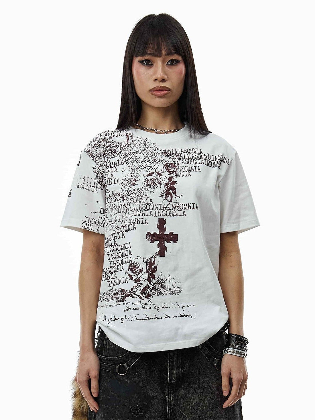 Close front view of the White Messages Tee with stacked bracelets and black jeans